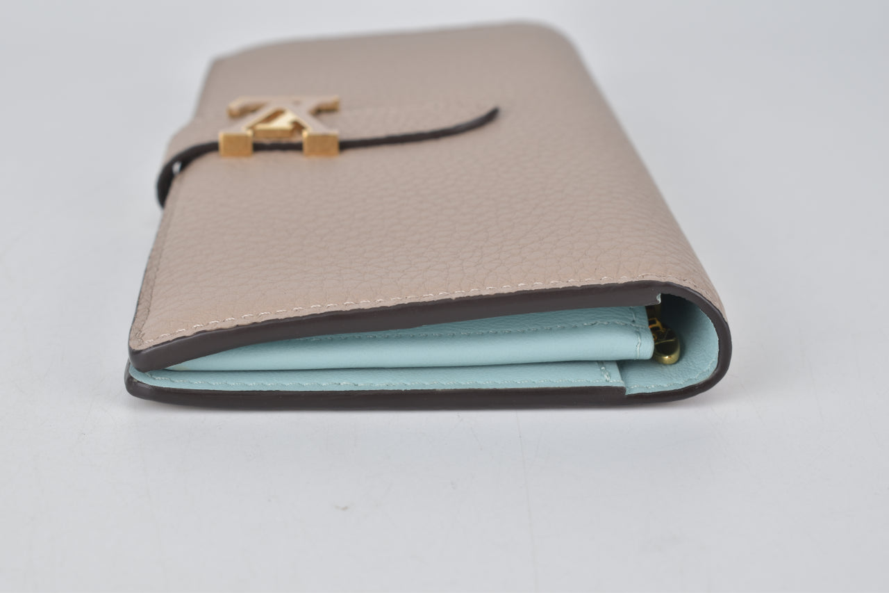 7372–6 M81367 LV Vertical Wallet in Taurillon Leather Galet Beige /  Aquamarine Blue Condition: Used 9/10 Remarks: Like new. Slight tarnish…