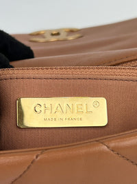 焦糖棕色手提包，配金色、银色和钌色金属