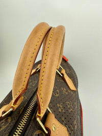 Close-up of a brown leather handle with gold stitching on a patterned bag.
