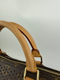 Close-up of a brown leather handle on a patterned handbag with a light gray background